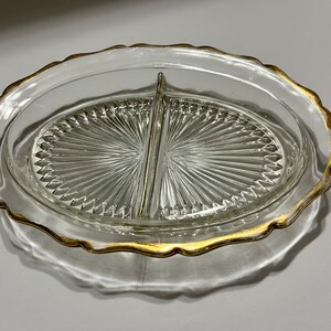 May include: A clear glass divided serving dish with a gold rim. The dish has a scalloped edge and a diamond pattern on the bottom.