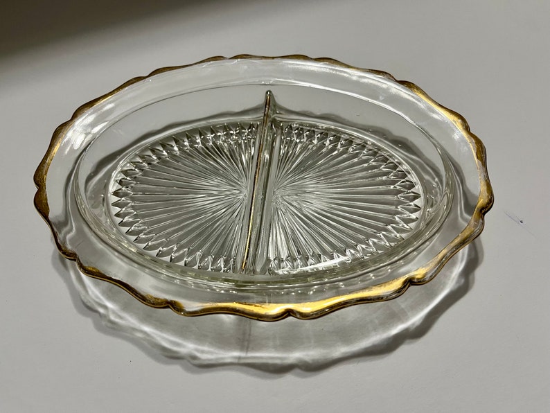 May include: A clear glass divided serving dish with a gold rim. The dish has a scalloped edge and a diamond pattern on the bottom.