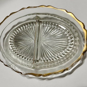May include: A clear glass divided serving dish with a gold rim. The dish has a diamond pattern and is divided into two sections.
