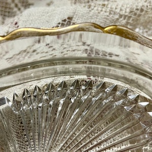 May include: A clear glass serving dish with a gold rim and a diamond-shaped pattern. The dish is divided into three sections.