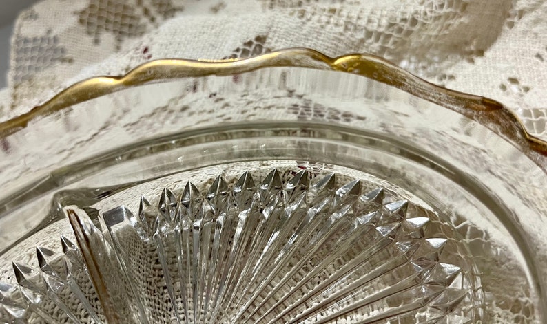 May include: A clear glass serving dish with a gold rim and a diamond-shaped pattern. The dish is divided into three sections.