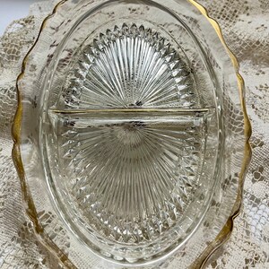May include: A clear glass divided serving dish with a gold rim. The dish has a diamond pattern and is divided into two sections.
