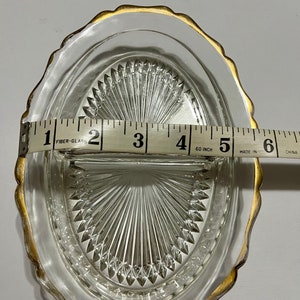 May include: A clear glass divided dish with a gold rim. The dish is 5 inches wide and has a diamond pattern.