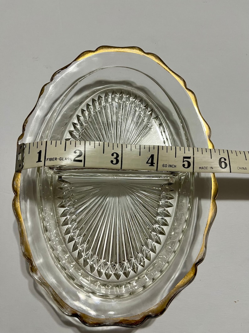 May include: A clear glass divided dish with a gold rim. The dish is 5 inches wide and has a diamond pattern.