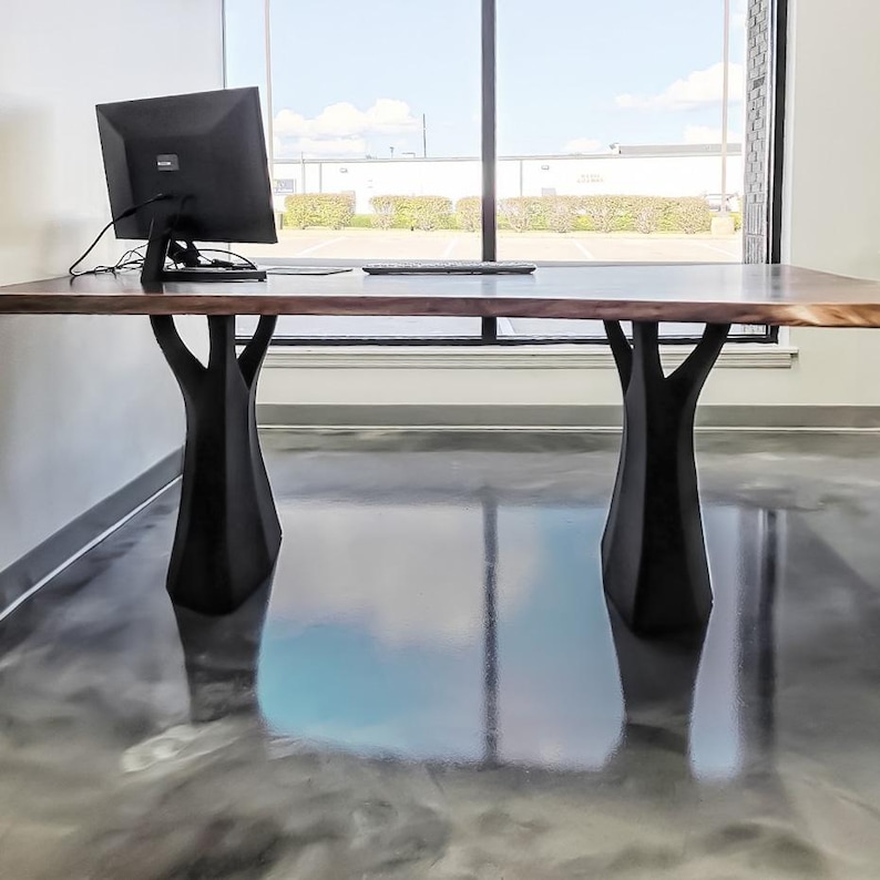 K&ouml;nnte beinhalten: Ein gro&szlig;er Holzschreibtisch mit einer dunkelbraunen Platte und schwarzen baumf&ouml;rmigen Beinen. Ein Computermonitor und eine Tastatur stehen auf dem Schreibtisch. Der Schreibtisch ist etwa 183 cm lang.