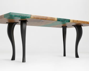 Könnte beinhalten: Rechteckiger Holztisch mit einem Design mit lebendiger Kante. Die Tischplatte besteht aus Naturholz und türkisfarbenem Harz. Der Tisch wird von vier schwarzen, gebogenen Beinen getragen. Der Tisch ist etwa 180 cm lang.