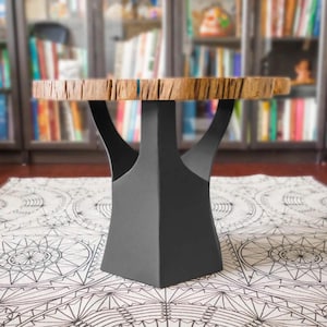 May include: A round wooden table with a natural edge, supported by a dark gray, geometric metal base. The table's top is approximately 30 inches in diameter, showcasing a light brown wood grain. The base has a unique, tree-like design.