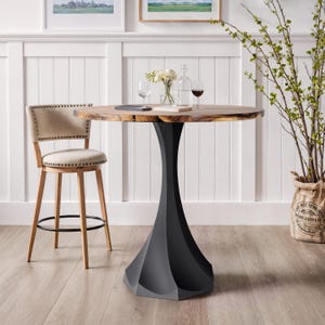 May include: A round wooden table with a black pedestal base. A beige upholstered bar stool with nailhead trim sits to the left. Wine glasses and a bottle of wine are on the table. The table is approximately 36 inches in diameter.
