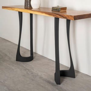 May include: A wooden console table with a live edge top and black metal hairpin legs. The table is 75 cm long and 30 cm wide.