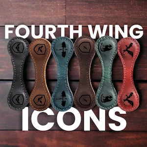 May include: Six leather keychains with different dragon designs. The keychains are in black, brown, blue, brown, green, and red. The text "FOURTH WING ICONS" is above the keychains.