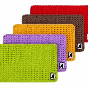 May include: A stack of rectangular, crocheted items in various colors: green, purple, gold, brown, and red. Each item has a small white square with a black graphic in the corner. The items are arranged in a staggered, ascending order.