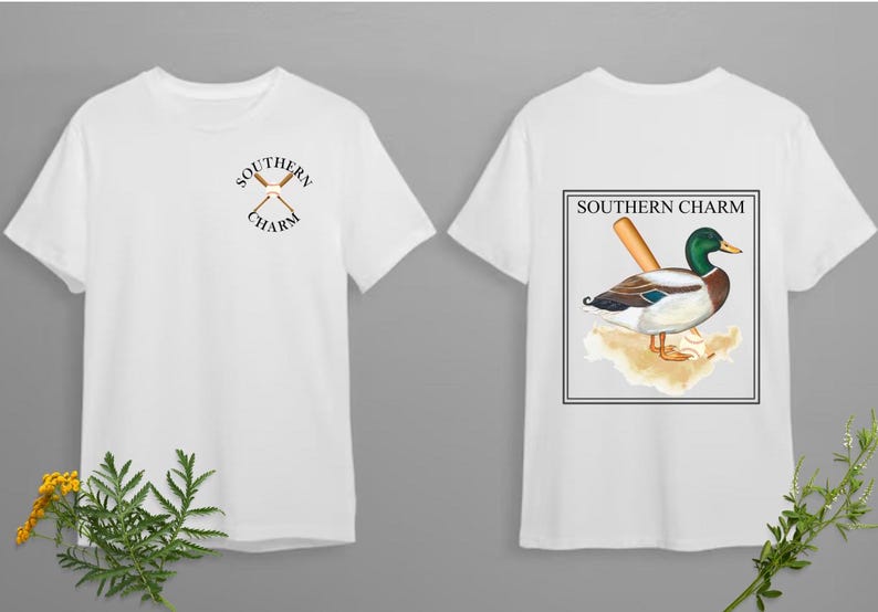 May include: White t-shirt with a graphic of crossed baseball bats and the text "Southern Charm" on the front. The back of the shirt features a graphic of a duck with a baseball bat and the text "Southern Charm" in a rectangular frame.