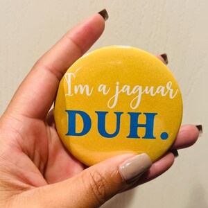 May include: A yellow button with the text "I'm a jaguar DUH." in white and blue lettering.