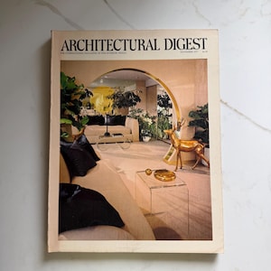 Może przedstawiać: Zestaw trzech ceramicznych kubków z nakrapianym, matowym wykończeniem. Kubki są w odcieniach kremu, jasnoszarym i ciemnoszarym. Każdy kubek ma prosty, minimalistyczny design.