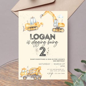 May include: A light beige birthday invitation with watercolor illustrations of construction vehicles. The text reads "LOGAN is digging being 2" and includes party details: date, time, and location.