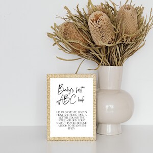 May include: A gold-framed sign with the text "Baby's first ABC book" and instructions for creating a personalized baby book.