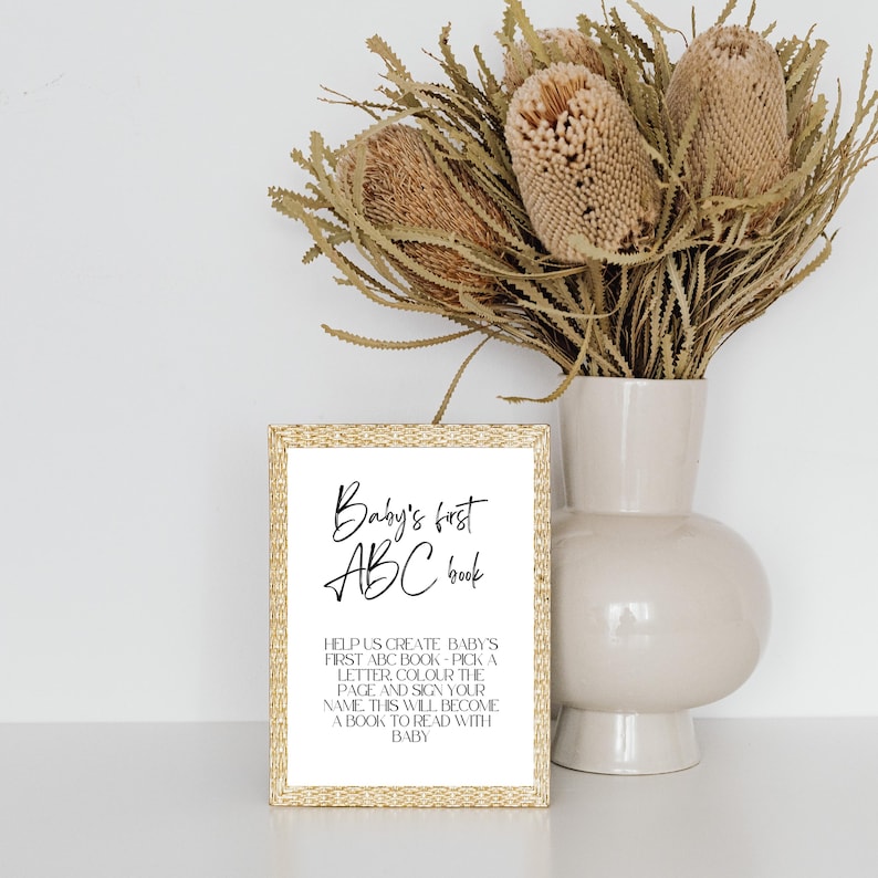 May include: A gold-framed sign with the text "Baby's first ABC book" and instructions for creating a personalized baby book.