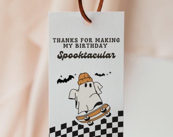 May include: A white gift tag with the text "THANKS FOR MAKING MY BIRTHDAY Spooktacular". The tag features a cartoon ghost wearing a beanie and riding a skateboard. Black bats and a checkered pattern complete the design.