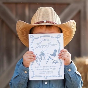 Könnte beinhalten: Ein Kind mit einem Cowboyhut aus Stroh und einem Jeanshemd hält eine hellblaue Einladung. Auf der Einladung steht "Can We Get a Three Haw" und sie enthält Illustrationen eines Cowboys auf einem Pferd, eines Stiefels und eines Hutes. Die Einladung enthält auch Datum, Uhrzeit und RSVP-Informationen.