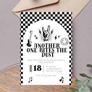May include: Black and white checkered background with a white circle containing a rock and roll themed birthday party invitation. The text reads "Another One Bites The Dust" and "Rock on over to celebrate Ozzy's First Birthday". The date is August 18th and the time is at five PM. The address is 123 Anywhere St. Any City, ST 12345. The RSVP number is 123-456-7890.