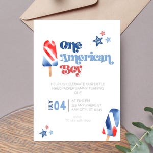 Peut inclure: Une carte d'invitation blanche avec des sucettes glacées en aquarelle rouge, blanche et bleue. Le texte indique "One American Boy" avec un motif d'étoile rouge, blanche et bleue. L'invitation est pour une fête de premier anniversaire et comprend la date, l'heure et le lieu.
