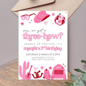 May include: Pink and red birthday party invitation with the text "can we get a three-haw?" and "margot's 3rd birthday". The invitation features a cowboy hat, sunglasses, a disco ball, a cactus, a guitar, a horseshoe, cowboy boots, and a denim jacket.