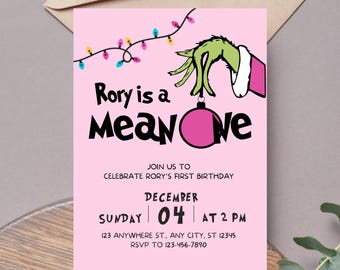 May include: Pink birthday invitation with the text "Rory is a Mean One." The invitation features a green hand holding a pink ornament, with colorful string lights above. The date is December 4th at 2 PM.