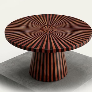 Könnte beinhalten: Ein runder Holztisch mit einem Sonnenstrahl-Design auf der Tischplatte. Der Tisch hat abwechselnde Streifen aus dunklem und hellem Holz, die von der Mitte ausstrahlen. Der Sockel ist konisch geformt und hat passende vertikale Streifen.