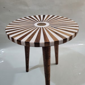 Three tiered tables made of walnut wood and resin. An elegant round table