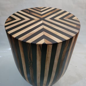 Cylindrical table striped table in walnut and resin.