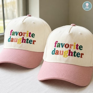 May include: Two baseball caps with a white crown and a pink bill. The phrase "favorite daughter" is embroidered in colorful letters on the front of each cap. The caps have a pink button on top.