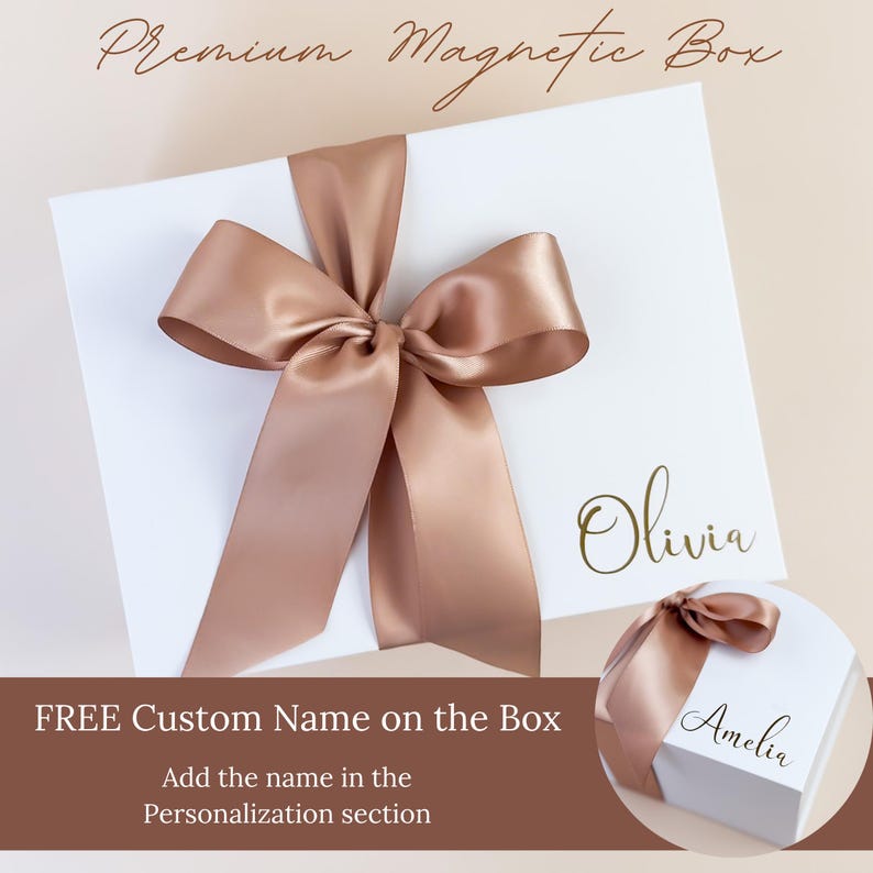 May include: A white magnetic gift box with a large, bronze satin bow. The box has the name "Olivia" in gold script. The text "FREE Custom Name on the Box" is also visible.