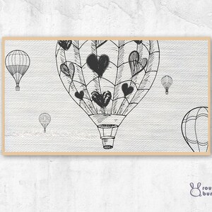 Może przedstawiać: Czarno-biała ilustracja balonów na gorące powietrze z sercami na tkaninie. Balony unoszą się w powietrzu.