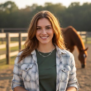 May include: A silver necklace with a linked design is worn by a person in a plaid shirt and green shirt. A brown horse is in the background near a wooden fence. The setting appears to be a farm or ranch.