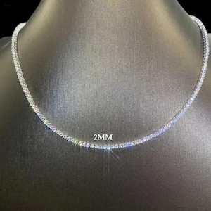 May include: A silver chain necklace with small, clear cubic zirconia stones. The chain is 2mm wide.
