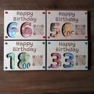 Könnte beinhalten: Vier Geburtstagskarten aus Holz mit der Aufschrift "Happy Birthday". Jede Karte hat eine ausgeschnittene Zahl, die mit Währung gefüllt ist, und einen QR-Code. Die Zahlen sind 66, 50, 18 und 33.