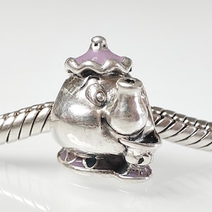 Puede incluir: Encanto de plata con forma de tetera con tapa morada y pico negro. El encanto tiene un diseño detallado y es perfecto para una pulsera o un collar.