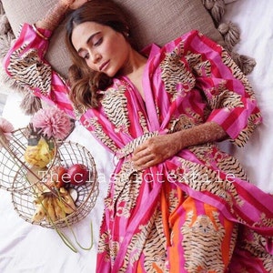May include: A pink and orange striped robe with a tiger print. The robe is tied at the waist and has long sleeves. The robe is made of a soft, comfortable fabric.