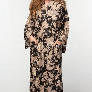 May include: A long black and beige floral print robe with a tie belt and pockets.