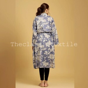May include: A long, blue floral print robe with a tie belt. The robe has a white floral pattern on a blue background.