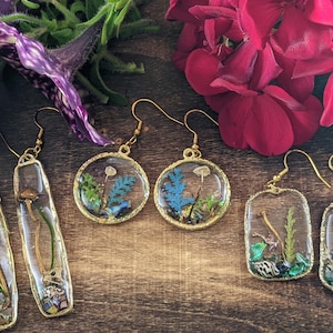 mushroom terrarium gold frame dangle and drop earrings. Botanical forest earrings made from resin, lichen, shells, ferns, moss & fungi