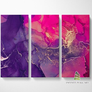 May include: Abstract triptych wall art in purple, pink, and gold. The artwork has a fluid, marbled appearance with gold accents. The rectangular pieces are mounted on a white background. The text "INFINITY WALL ART" is visible.