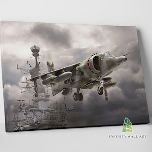 May include: Canvas print featuring a military aircraft in flight, set against a backdrop of a cloudy sky and a naval vessel. The aircraft is painted in shades of green and gray, with visible details of its design. The artwork is titled "INFINITY WALL ART".