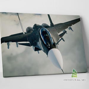 May include: A black fighter jet flies through the clouds. The jet has a white nose cone and a clear cockpit.