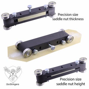 Könnte beinhalten: Ein schwarzes Präzisionswerkzeug für die Dicke und Höhe von Gitarrensattelmuttern mit silberfarbener Hardware. Das Werkzeug hat vier Rollenlager und verstellbare Schrauben. Der Text "Precision size saddle nut thickness" und "Precision size saddle nut height" sind sichtbar.