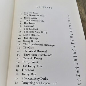 Puede incluir: Un libro titulado "CONTENTS" con una lista de cap&iacute;tulos y n&uacute;meros de p&aacute;gina. Los cap&iacute;tulos incluyen "Hopeful Farm", "The November Sales", "Home Again", "The Reluctant Filly", "Hot Potato", "Runaway!", "The Yardstick", "The Santa Anita Derby", "Derby Hopefuls", "The Flamingo", "Spring Breezes", "The Experimental Handicaps", "The Gate", "The Wood Memorial", "Show those Hardboots!", "Churchill Downs", "Derby Week", "The Derby Trial", "First Start", "Derby Day", "The Kentucky Derby" y "Anything can happen..."