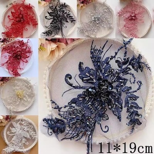 May include: A selection of embroidered lace appliques in red, black, silver, and pink. The appliques showcase floral and abstract patterns, with bead and sequin details. The largest applique is navy blue, measuring 11 x 19 cm.