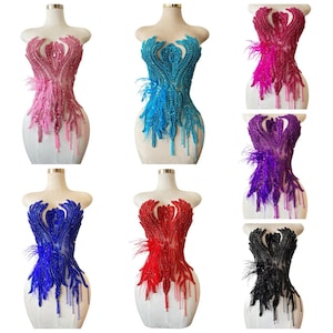 Op de afbeelding: Zes geborduurde lijfjes in roze, blauw, paars, rood en zwart, elk met veeraccenten. De lijfjes worden op paspoppen gepresenteerd, die hun ingewikkelde patronen en texturen laten zien. De ontwerpen bevatten een verscheidenheid aan kralenwerk en versieringen.
