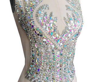 May include: A large, iridescent rhinestone applique in a floral design. The applique is perfect for adding sparkle and glamour to clothing, bags, or other crafts.