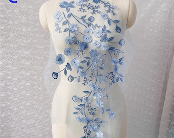 Peut inclure: Applique de broderie florale bleue avec des fleurs et des feuilles délicates sur un tissu en maille transparente. Cette applique est parfaite pour ajouter une touche d'élégance aux vêtements, aux accessoires ou aux projets de décoration intérieure.